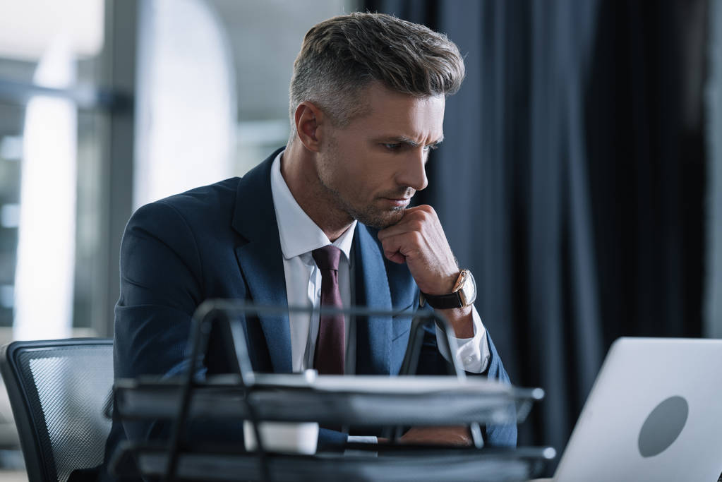 Focused businessman in suit working intently at office desk